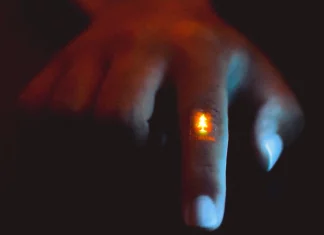 Zhitao Zhang wears the flexible light-emitting film, featuring a Stanford logo, on the knuckle of their finger. This shows how the film can hold up to flexing and wrinkling. (Image credit: Zhitao Zhang and Jiancheng Lai of Bao Group Research Lab)