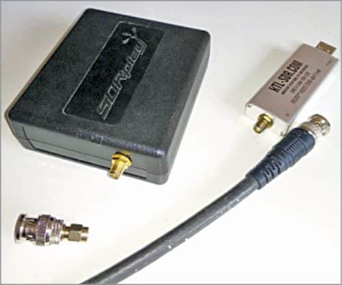 Receiver RSP1A from SDRPlay (left) and RTL-SDR dongle V3 (right); cable assembly and BNC-to-SMA adaptor are in the fore