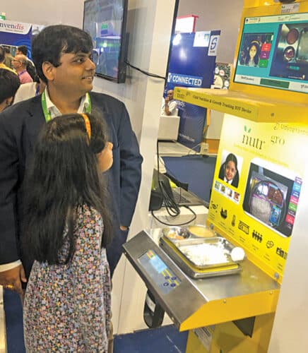 Ankur Jain, Founder & CEO of UdyogYantra with a small girl testing their device