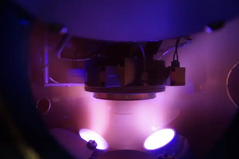 Argon plasma in the vacuum chamber during magnetron sputtering, with the substrate in the centre of the photograph