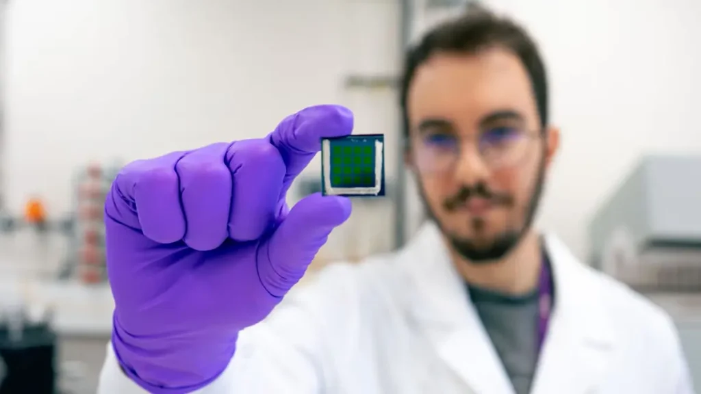 Image of one of the researchers holding the new solar cell.