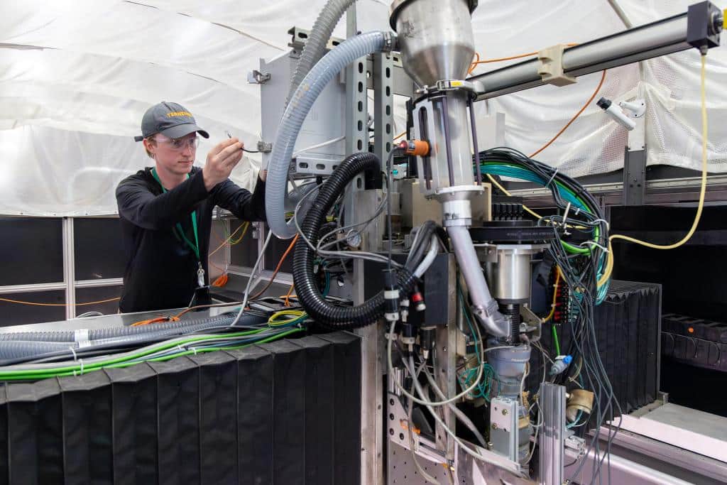 University of Tennessee graduate student Chris O’Brien sets up the 3D-printing apparatus at ORNL to test a new sensing and control technology for creating large objects with plastic composite. Credit: Alonda Hines/ORNL, U.S. Dept. of Energy