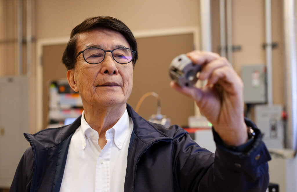Professor Paul Ching-Wu Chu holds a diamond anvil cell (DAC) in a University of Houston lab. The DAC was used to help the UH team break the temperature record for superconductivity at ambient pressure.