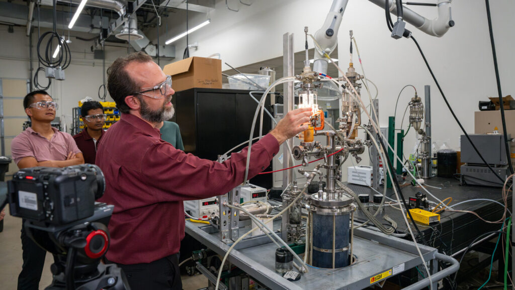 Dr. David Staack demonstrates the plasma-based reactor used to convert methane into graphene oxide and hydrogen.
