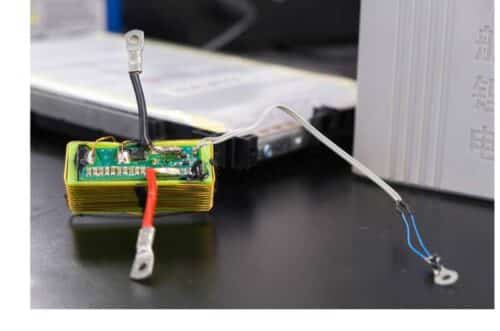 The green circuit board contains the electronic circuit developed by the researchers to transmit sensor data through the existing power terminals of a battery cell. The battery cell is shown in the background. Credit: Christina Anders, Uni Kiel