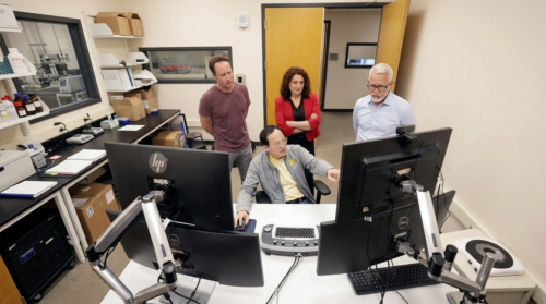 University of Michigan researchers examining data on monitors in a materials science lab