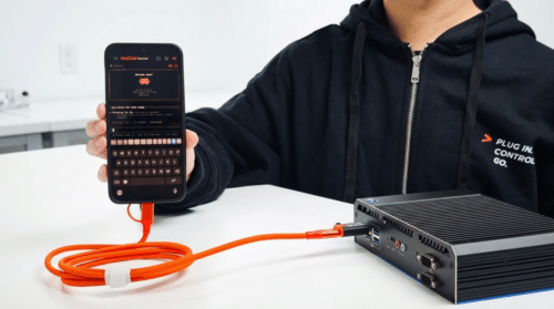 Person using the KeyCmd app on a smartphone to send terminal commands to a mini PC via Openterface KeyMod