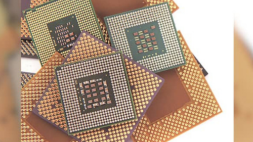 Close-up of semiconductor chip packages showing gold connector pins and ceramic substrate