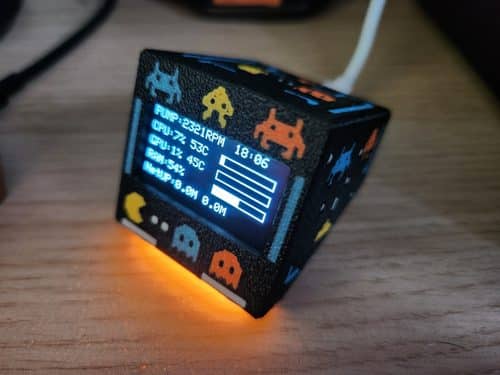 SmallOLED in a black 3D-printed arcade-style case showing pump speed, CPU and GPU load and temperature, RAM use and network traffic on a small OLED