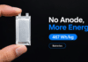 Anode-Free Lithium Battery Reaches 467Wh/kg Thin silver anode-free battery pouch cell held between two fingers against a dark background.