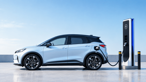 Silver electric hatchback connected to a high-power EV charging station against a clean blue background.