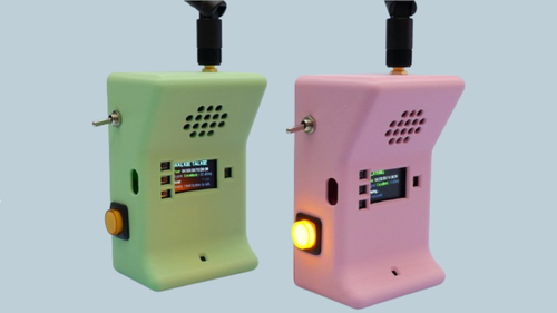 Two 3D-printed ESP32-S3 walkie-talkie handsets, green and pink, with antennas and illuminated push buttons, displaying signal status on their screens