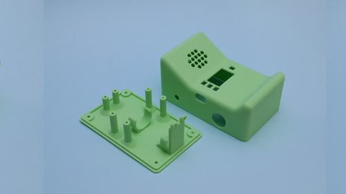 A 3D-printed green enclosure for the ESP32 walkie-talkie, shown open with mounting posts for the circuit board and components