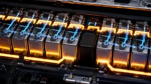 Close-up of battery cells with individual control chips and illuminated circuit traces, with one cell disconnected from the active pathway